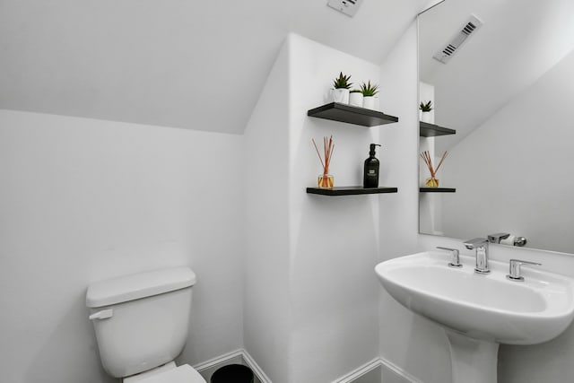 bathroom with lofted ceiling, sink, and toilet