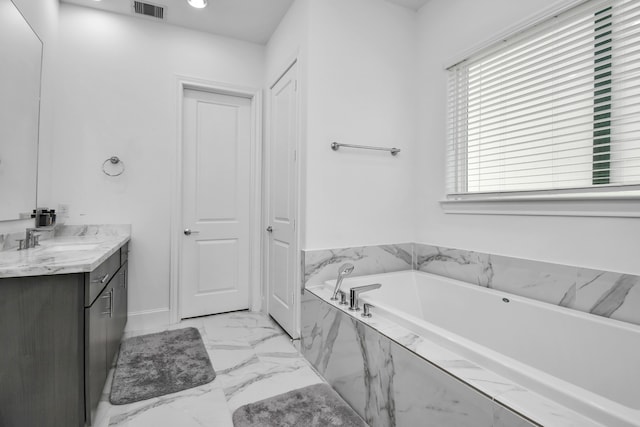 bathroom with vanity and a relaxing tiled tub