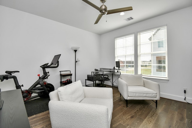 sitting room with dark wood-type flooring, ceiling fan, and a healthy amount of sunlight