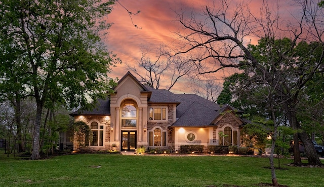 66 Bees Creek Rd, Missouri City, TX 77459 - view of front facade with stone siding, a yard, french doors, and stucco siding