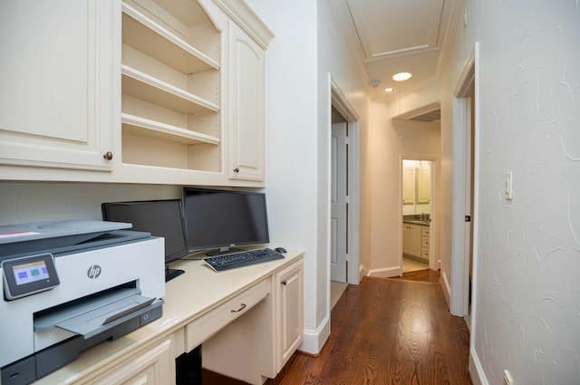 home office with built in desk, dark hardwood / wood-style floors, and sink