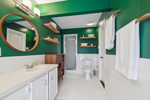 bathroom with walk in shower, tile patterned flooring, vanity, toilet, and tile walls