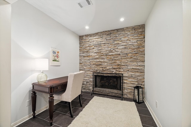 office area with a fireplace and dark tile patterned flooring