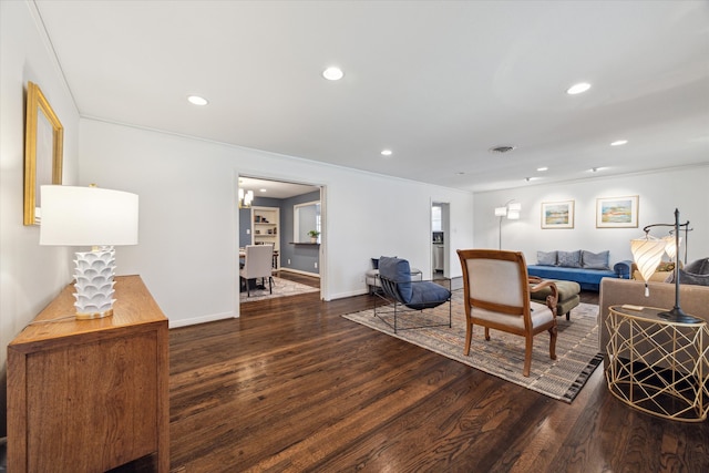 living room with a chandelier, dark hardwood / wood-style floors, and crown molding