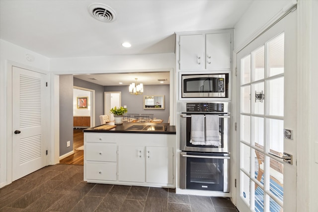 kitchen featuring an inviting chandelier, hanging light fixtures, dark hardwood / wood-style floors, white cabinetry, and appliances with stainless steel finishes