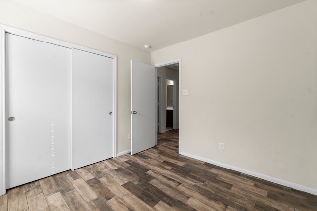 unfurnished bedroom featuring a closet and dark hardwood / wood-style flooring