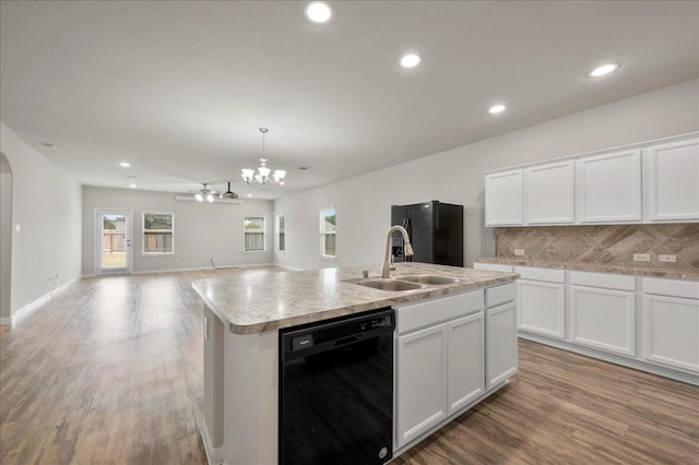 kitchen with white cabinets, backsplash, a kitchen island with sink, and black appliances