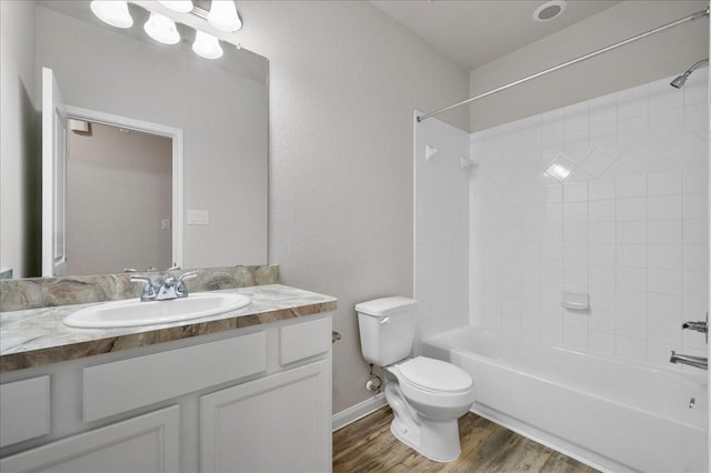 full bathroom with vanity, toilet, wood-type flooring, and tiled shower / bath combo