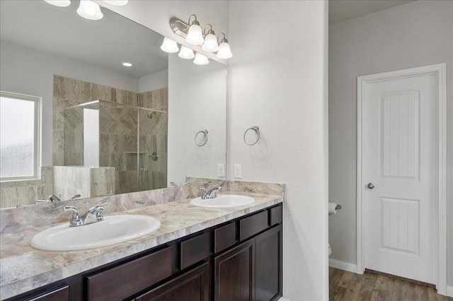 bathroom with wood-type flooring, vanity, toilet, and a shower with shower door