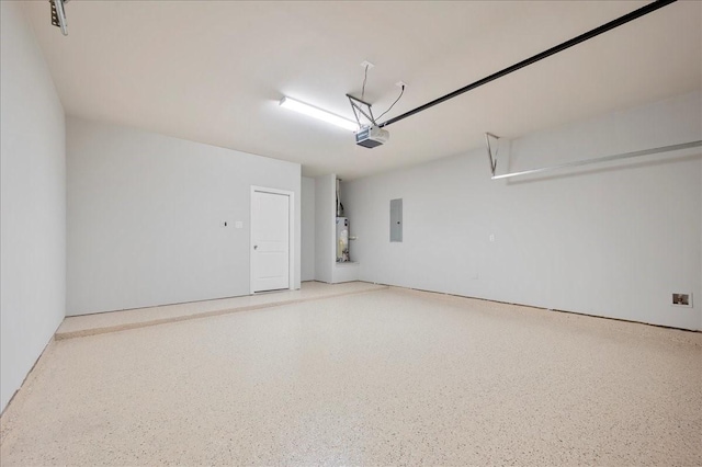 garage featuring gas water heater, a garage door opener, and electric panel