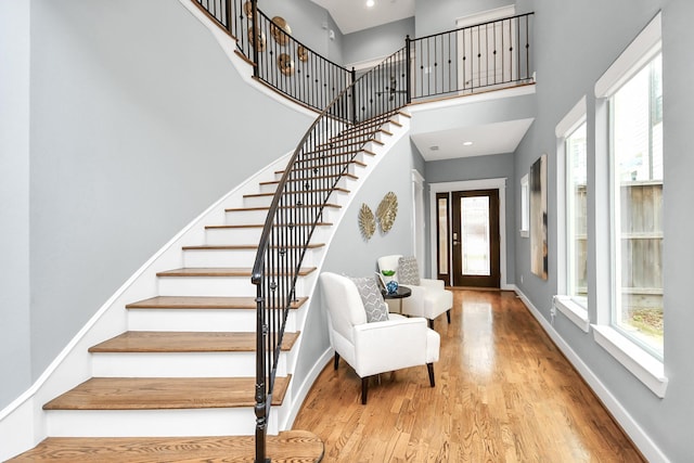 entrance foyer featuring a towering ceiling and light hardwood / wood-style floors