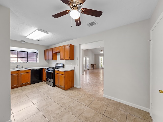 kitchen featuring black dishwasher, a textured ceiling, sink, gas stove, and light tile patterned floors