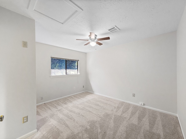 carpeted spare room featuring a textured ceiling and ceiling fan