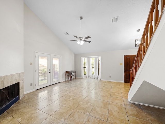 unfurnished living room featuring high vaulted ceiling, french doors, light tile patterned flooring, and plenty of natural light