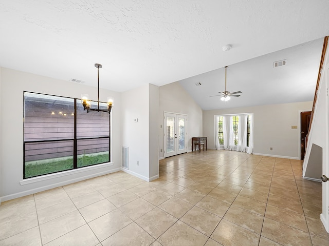 unfurnished living room with light tile patterned flooring, ceiling fan with notable chandelier, a textured ceiling, high vaulted ceiling, and french doors