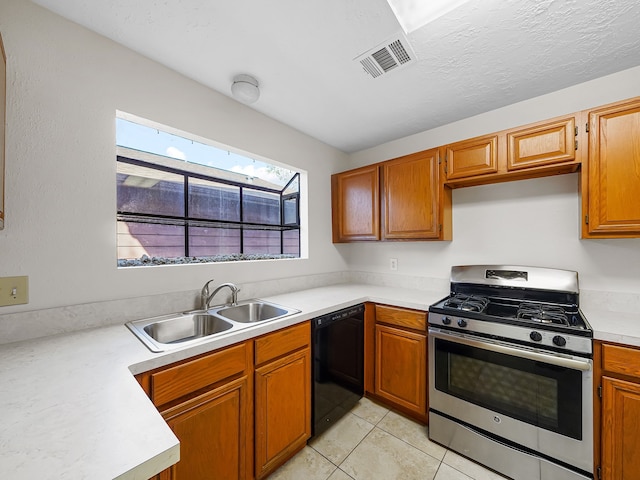 kitchen featuring light tile patterned floors, stainless steel gas range, sink, and black dishwasher