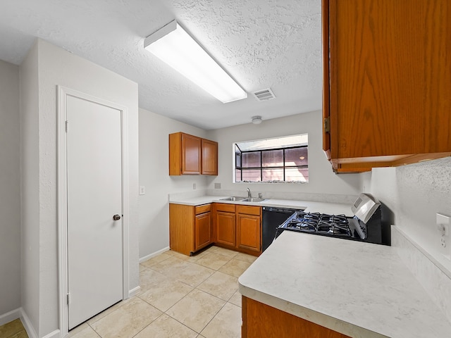 kitchen with black appliances, sink, light tile patterned floors, and a textured ceiling