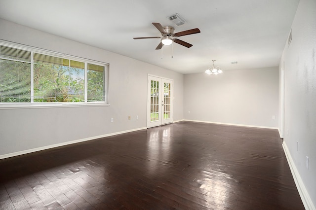 empty room featuring french doors, ceiling fan with notable chandelier, and dark hardwood / wood-style floors