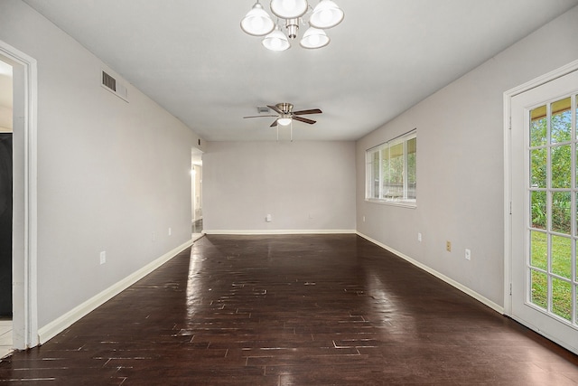 spare room with ceiling fan with notable chandelier and dark hardwood / wood-style flooring