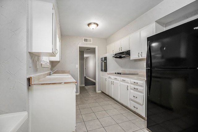 kitchen with light tile patterned floors, white cabinetry, sink, and black appliances