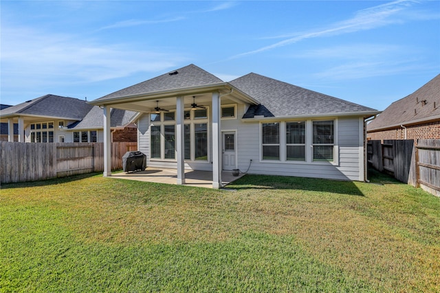 back of property with ceiling fan, a lawn, and a patio area