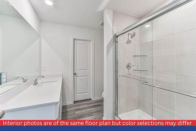 bathroom with hardwood / wood-style flooring, vanity, toilet, and walk in shower