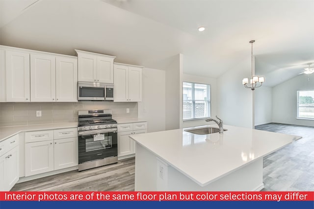 kitchen with white cabinets, lofted ceiling, sink, and appliances with stainless steel finishes