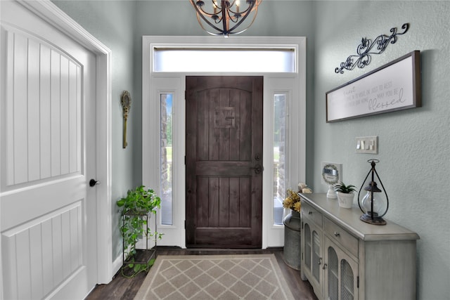 entryway with dark hardwood / wood-style floors and an inviting chandelier