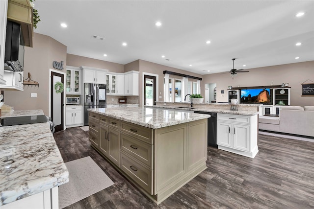 kitchen with dark wood-type flooring, white cabinets, kitchen peninsula, black appliances, and sink