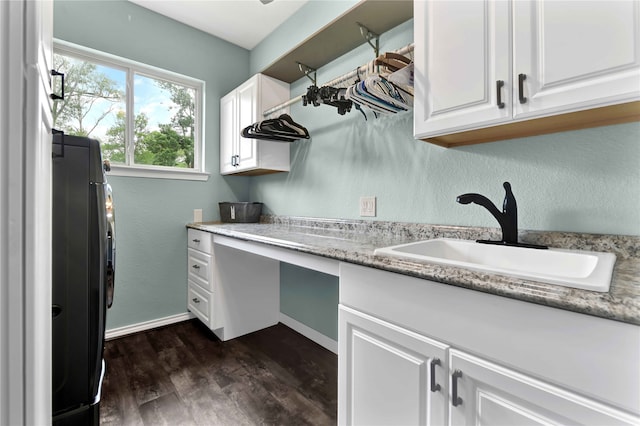 washroom featuring dark wood-type flooring, washer / clothes dryer, cabinets, and sink