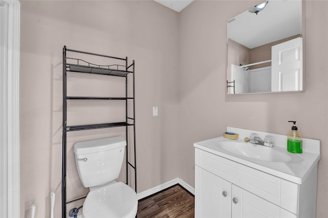 bathroom with wood-type flooring, toilet, and vanity