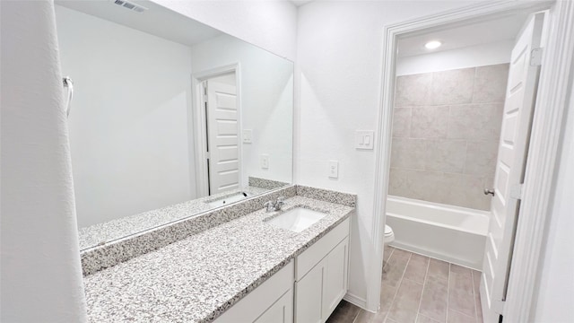 full bathroom featuring hardwood / wood-style floors, vanity, tiled shower / bath combo, and toilet