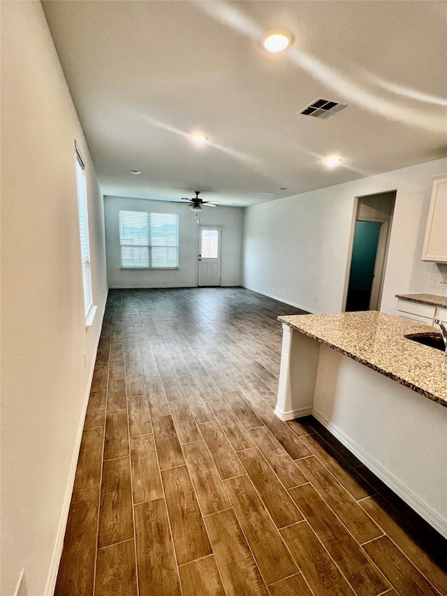 unfurnished living room featuring dark hardwood / wood-style flooring and ceiling fan