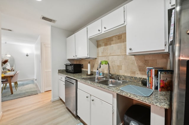 kitchen with white cabinetry, sink, appliances with stainless steel finishes, backsplash, and light hardwood / wood-style flooring