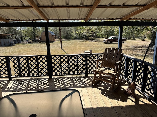 wooden deck with a yard and a storage unit