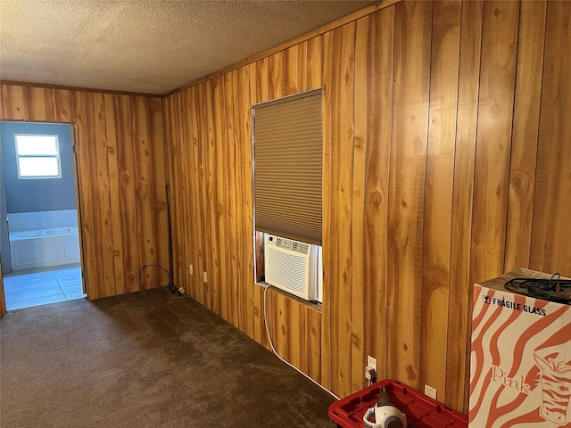 empty room featuring carpet flooring, cooling unit, a textured ceiling, and wood walls