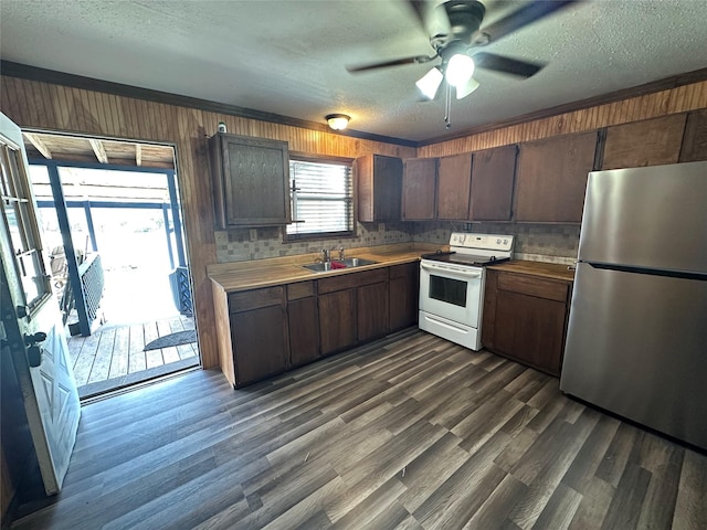 kitchen featuring white electric range, stainless steel refrigerator, sink, dark wood-type flooring, and dark brown cabinets