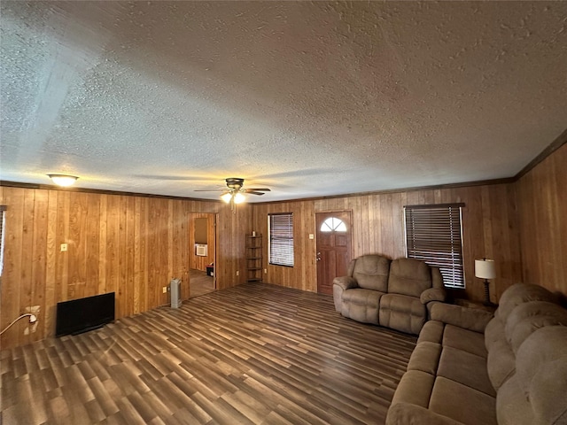 unfurnished living room with ceiling fan, hardwood / wood-style floors, a textured ceiling, and wood walls