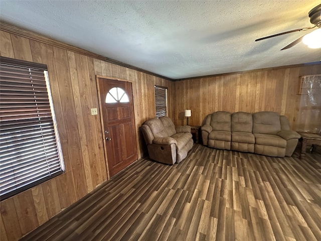 living room with wooden walls, dark hardwood / wood-style floors, and a textured ceiling