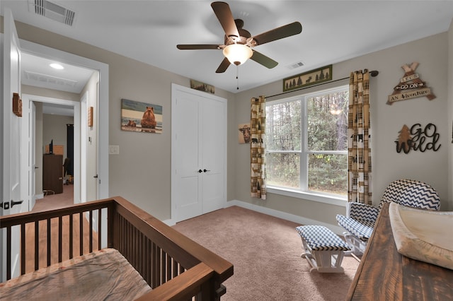 bedroom with ceiling fan, a closet, a nursery area, and carpet