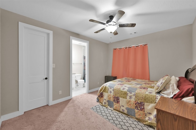 bedroom with ceiling fan, ensuite bath, and light carpet