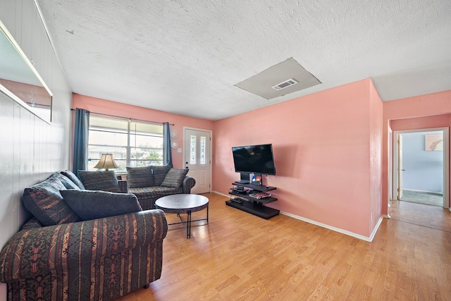 living room featuring a textured ceiling and light hardwood / wood-style floors