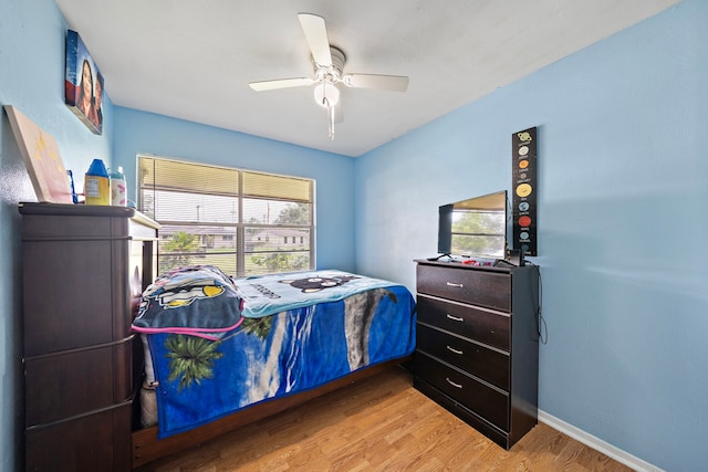 bedroom featuring wood-type flooring, multiple windows, and ceiling fan