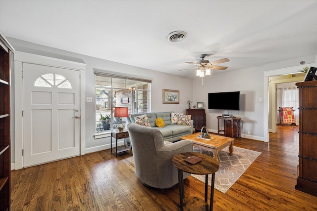 living room with ceiling fan and dark wood-type flooring