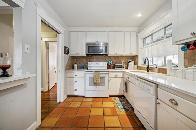 kitchen featuring sink, tasteful backsplash, light tile patterned flooring, white appliances, and white cabinets