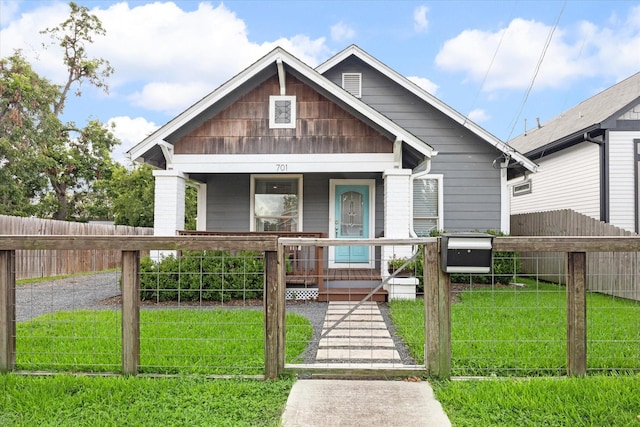 bungalow with covered porch and a front yard