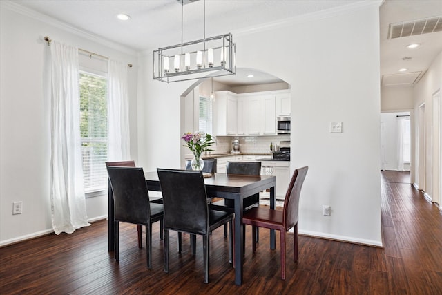 dining room featuring dark wood-type flooring and crown molding