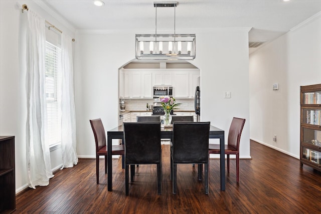 dining area featuring dark hardwood / wood-style flooring and ornamental molding