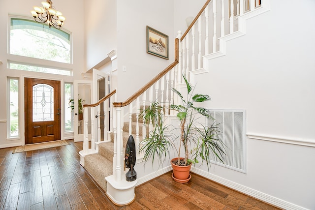 entrance foyer featuring dark hardwood / wood-style floors, a high ceiling, and an inviting chandelier