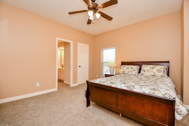 carpeted bedroom with ceiling fan and ensuite bath